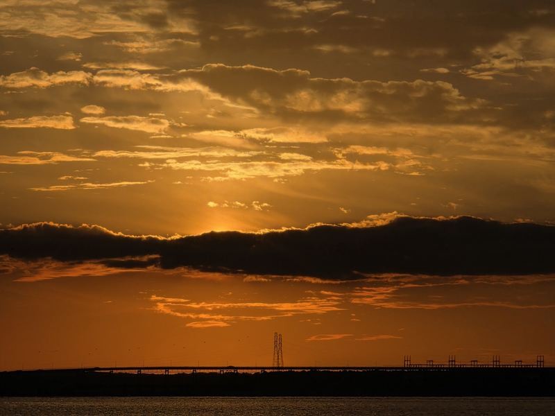 Sun rays through gold clouds above the dam