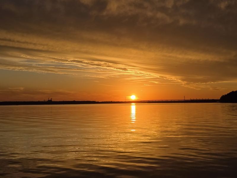 Golden sunset with the sun reflected on calm water