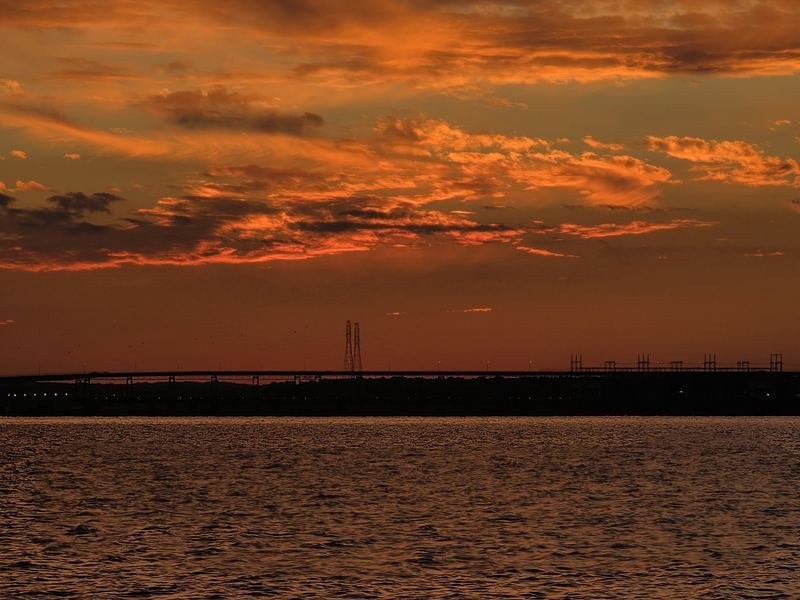 Red clouds over the bridge and dam at dusk